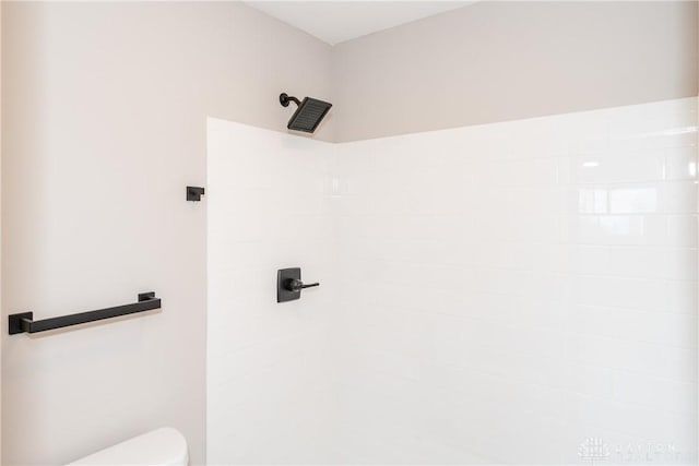 full bath featuring a tile shower and toilet
