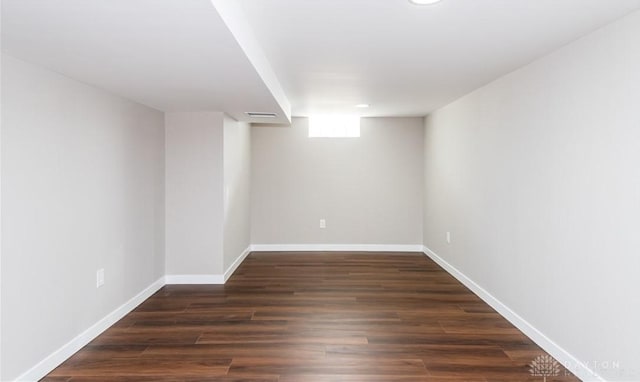 basement with wood finished floors, visible vents, and baseboards