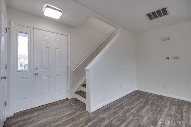 entrance foyer featuring stairway, baseboards, visible vents, and wood finished floors