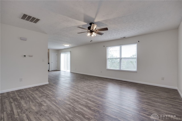 spare room featuring baseboards, ceiling fan, visible vents, and wood finished floors