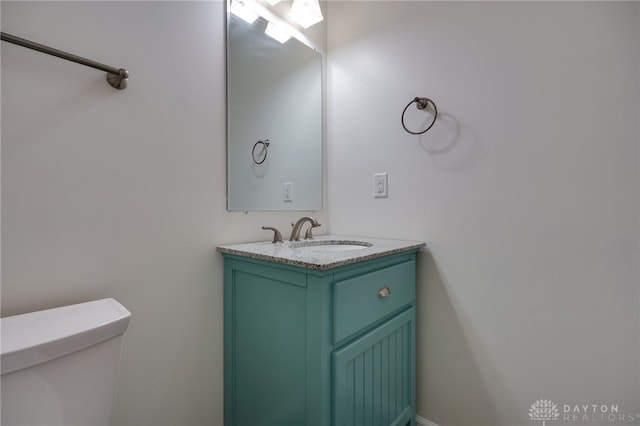 half bathroom with vanity and toilet