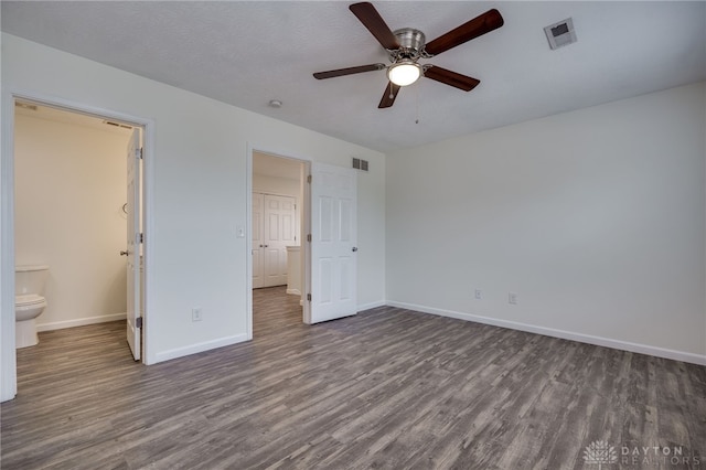 unfurnished bedroom with a textured ceiling, wood finished floors, visible vents, and baseboards