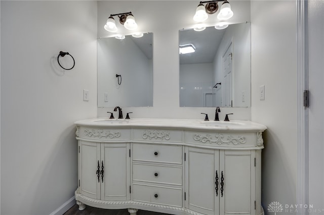 bathroom featuring a sink, baseboards, and double vanity