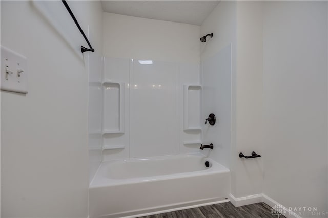 full bath featuring  shower combination, baseboards, and wood finished floors