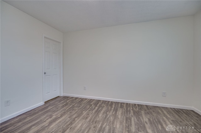 empty room featuring baseboards and wood finished floors