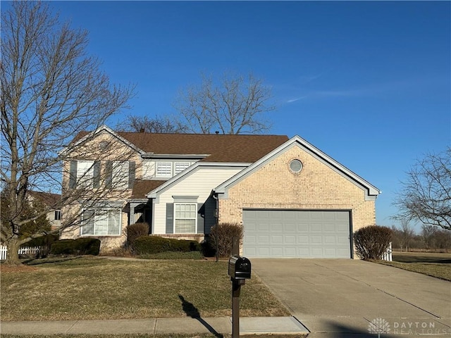 traditional home with driveway, an attached garage, a front lawn, and brick siding