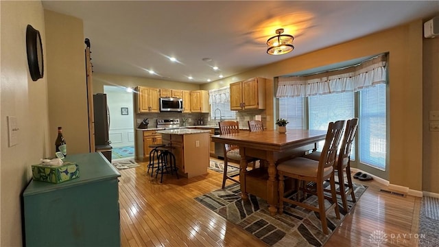 dining area featuring a healthy amount of sunlight, light wood-style floors, baseboards, and visible vents