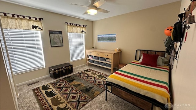 carpeted bedroom with a ceiling fan, visible vents, and baseboards