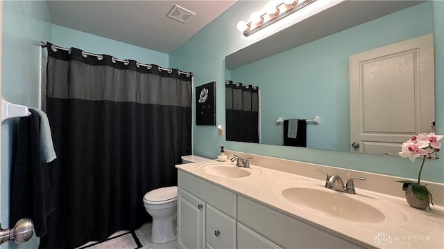 bathroom with visible vents, a sink, toilet, and double vanity