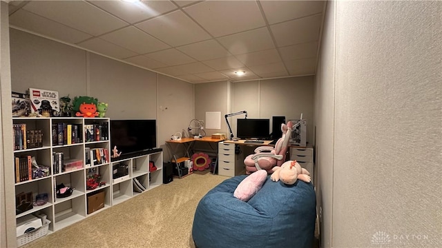 interior space with a paneled ceiling, carpet flooring, and a textured wall