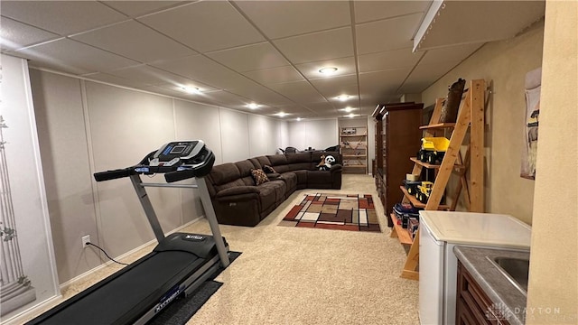 exercise area with carpet floors, a paneled ceiling, and a decorative wall