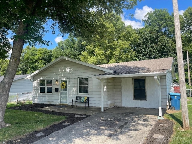 single story home with a shingled roof and a patio area