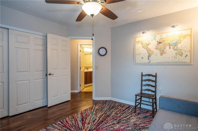 bedroom with dark wood-style floors, ceiling fan, a closet, and baseboards