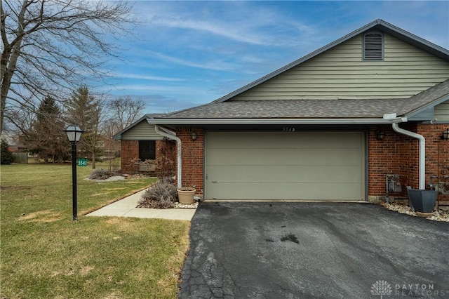 view of side of home with a garage, roof with shingles, brick siding, and a lawn