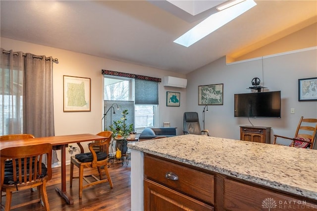 kitchen with dark wood-style flooring, a wall unit AC, lofted ceiling with skylight, open floor plan, and light stone countertops