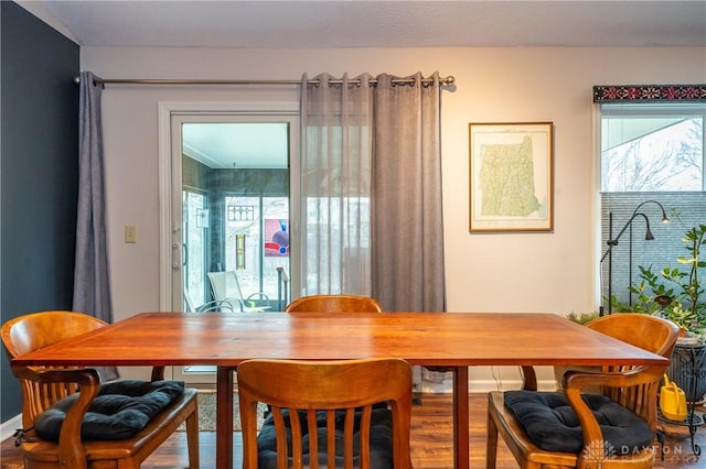 dining space with baseboards and wood finished floors