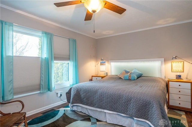 bedroom with ornamental molding, wood finished floors, and visible vents