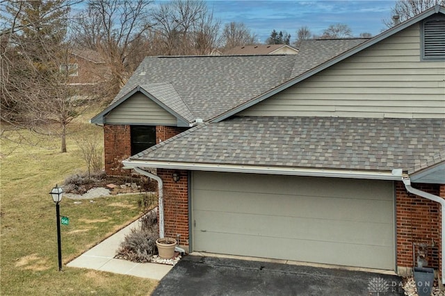 view of home's exterior featuring roof with shingles, brick siding, and a lawn