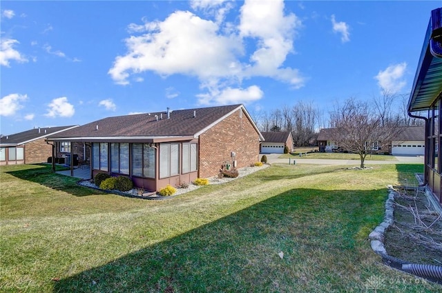 view of property exterior with brick siding, a lawn, and a sunroom