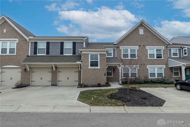 townhome / multi-family property featuring driveway, roof with shingles, a garage, and brick siding