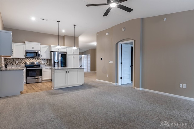 kitchen featuring visible vents, light colored carpet, stainless steel appliances, white cabinetry, and backsplash