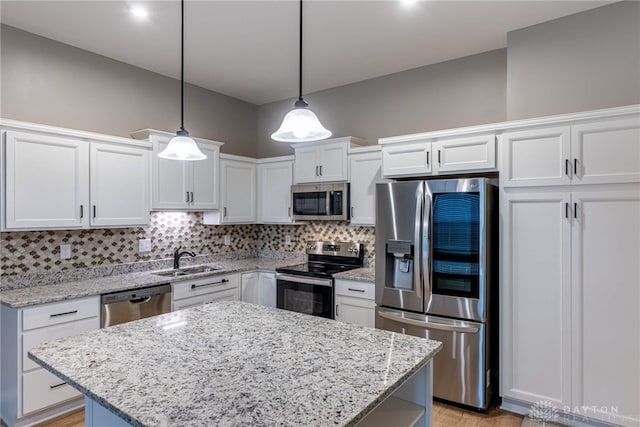 kitchen with white cabinetry, appliances with stainless steel finishes, decorative backsplash, and a sink