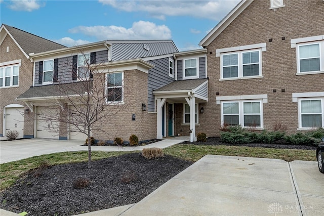 multi unit property featuring driveway, brick siding, and an attached garage