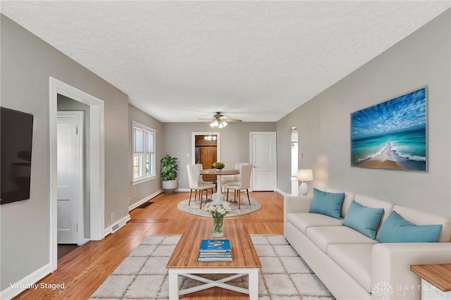 543 W Market St, Germantown, OH 45327 - living area with a ceiling fan, light wood-style floors, baseboards, and a textured ceiling