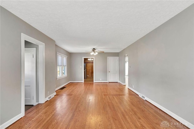 543 W Market St, Germantown, OH 45327 - unfurnished living room with a ceiling fan, light wood-type flooring, baseboards, and a textured ceiling