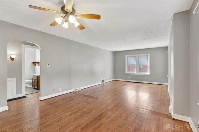 543 W Market St, Germantown, OH 45327 - empty room with arched walkways, ceiling fan, wood finished floors, a textured ceiling, and baseboards
