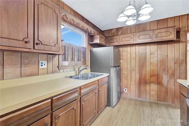 543 W Market St, Germantown, OH 45327 - kitchen with freestanding refrigerator, a sink, light wood-type flooring, a chandelier, and light countertops