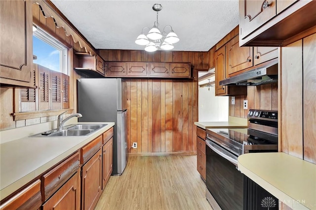 543 W Market St, Germantown, OH 45327 - kitchen featuring appliances with stainless steel finishes, under cabinet range hood, a sink, light wood-style flooring, and a chandelier