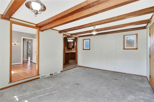 543 W Market St, Germantown, OH 45327 - carpeted empty room featuring arched walkways, beamed ceiling, baseboards, and healthy amount of natural light