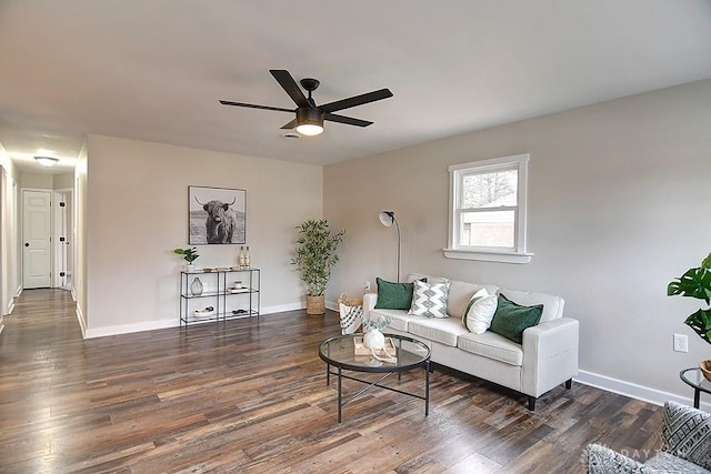 living area featuring a ceiling fan, baseboards, and wood finished floors