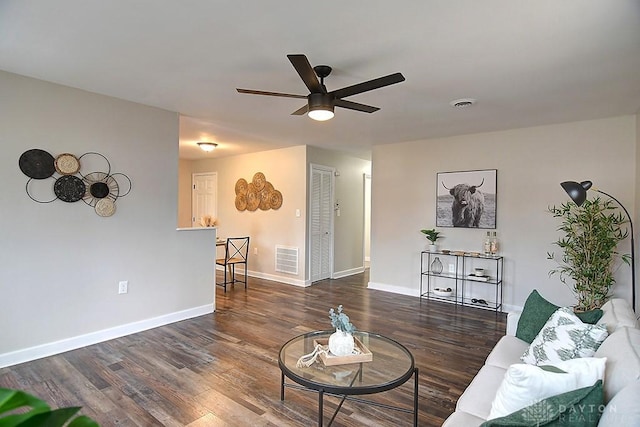 living area with a ceiling fan, wood finished floors, visible vents, and baseboards