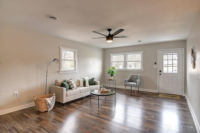 living area featuring dark wood-type flooring, a wealth of natural light, and baseboards