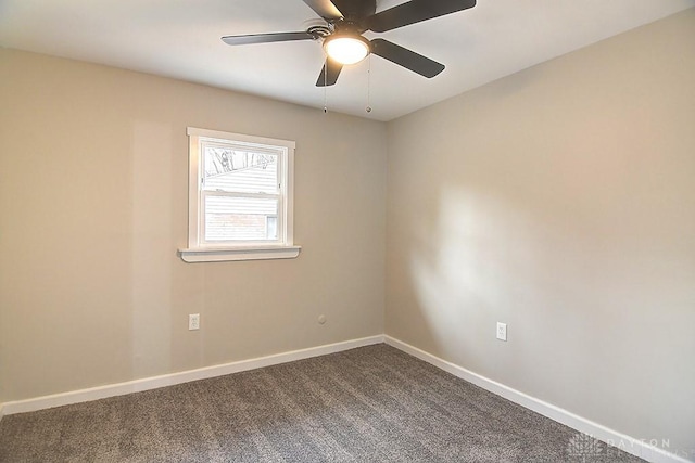 spare room with dark colored carpet, ceiling fan, and baseboards