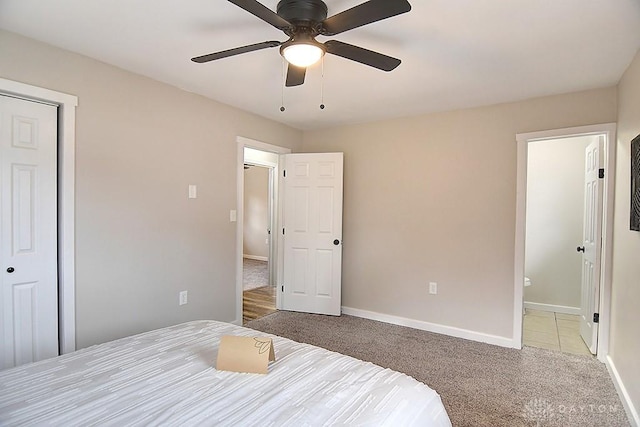 carpeted bedroom with baseboards and a ceiling fan