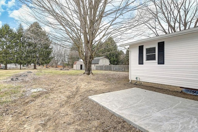 view of yard with a patio area, fence, a storage unit, and an outdoor structure