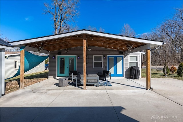 rear view of house featuring a patio area, outdoor lounge area, and french doors