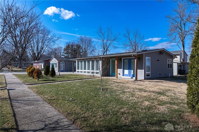 view of front of house with a front lawn and a sunroom