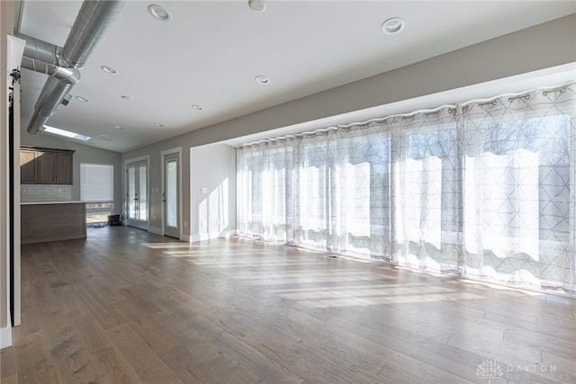 unfurnished living room with dark wood finished floors and recessed lighting