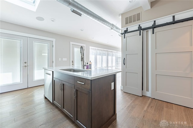 kitchen featuring visible vents, dishwasher, dark brown cabinets, french doors, and a sink