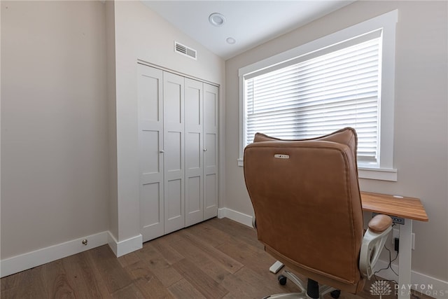 office with a healthy amount of sunlight, baseboards, visible vents, and wood finished floors