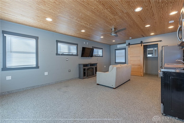 living area featuring ceiling fan, a barn door, recessed lighting, wood ceiling, and concrete block wall