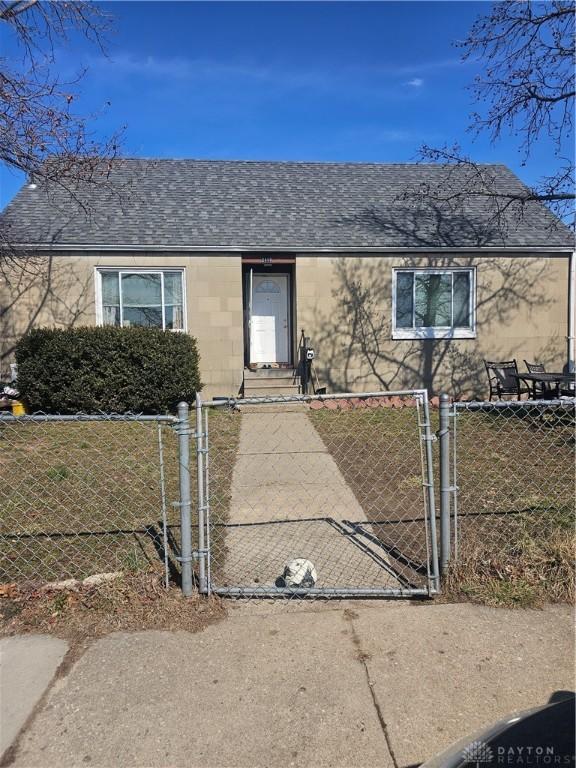 view of front of house with roof with shingles, a gate, and a fenced front yard