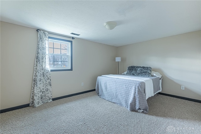 carpeted bedroom featuring visible vents, a textured ceiling, and baseboards