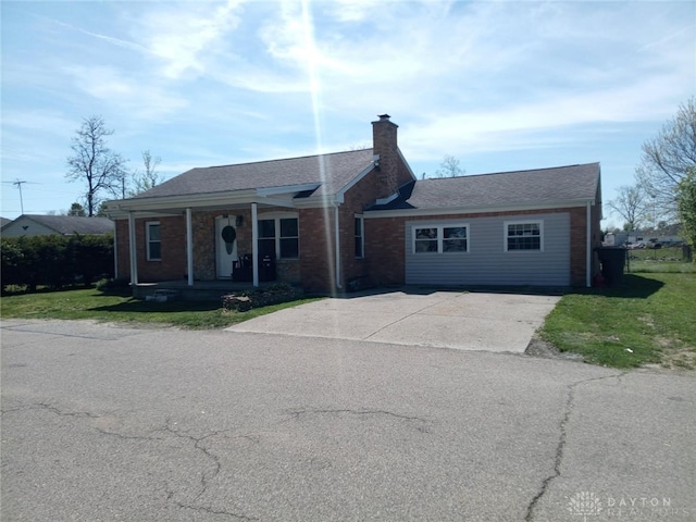 single story home featuring a chimney, covered porch, brick siding, driveway, and a front yard