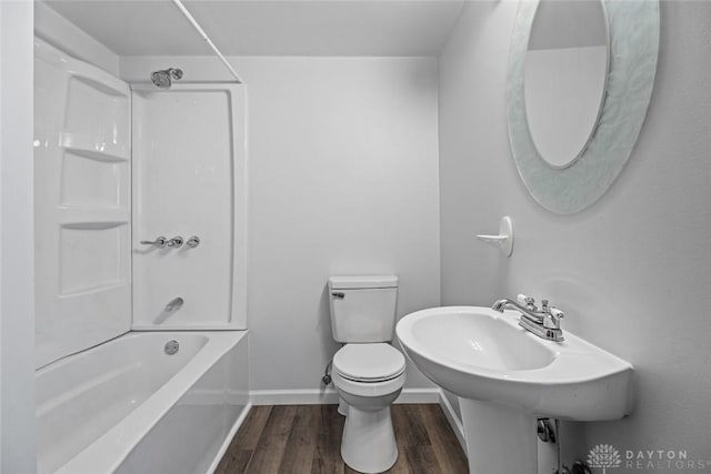 full bath with toilet, baseboards, wood finished floors, and bathing tub / shower combination