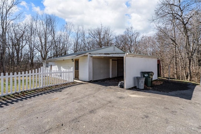 garage with fence and driveway